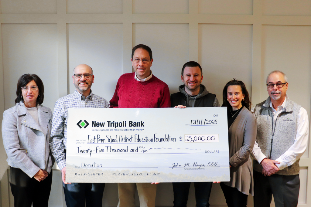 Photo of six people standing with a large check.