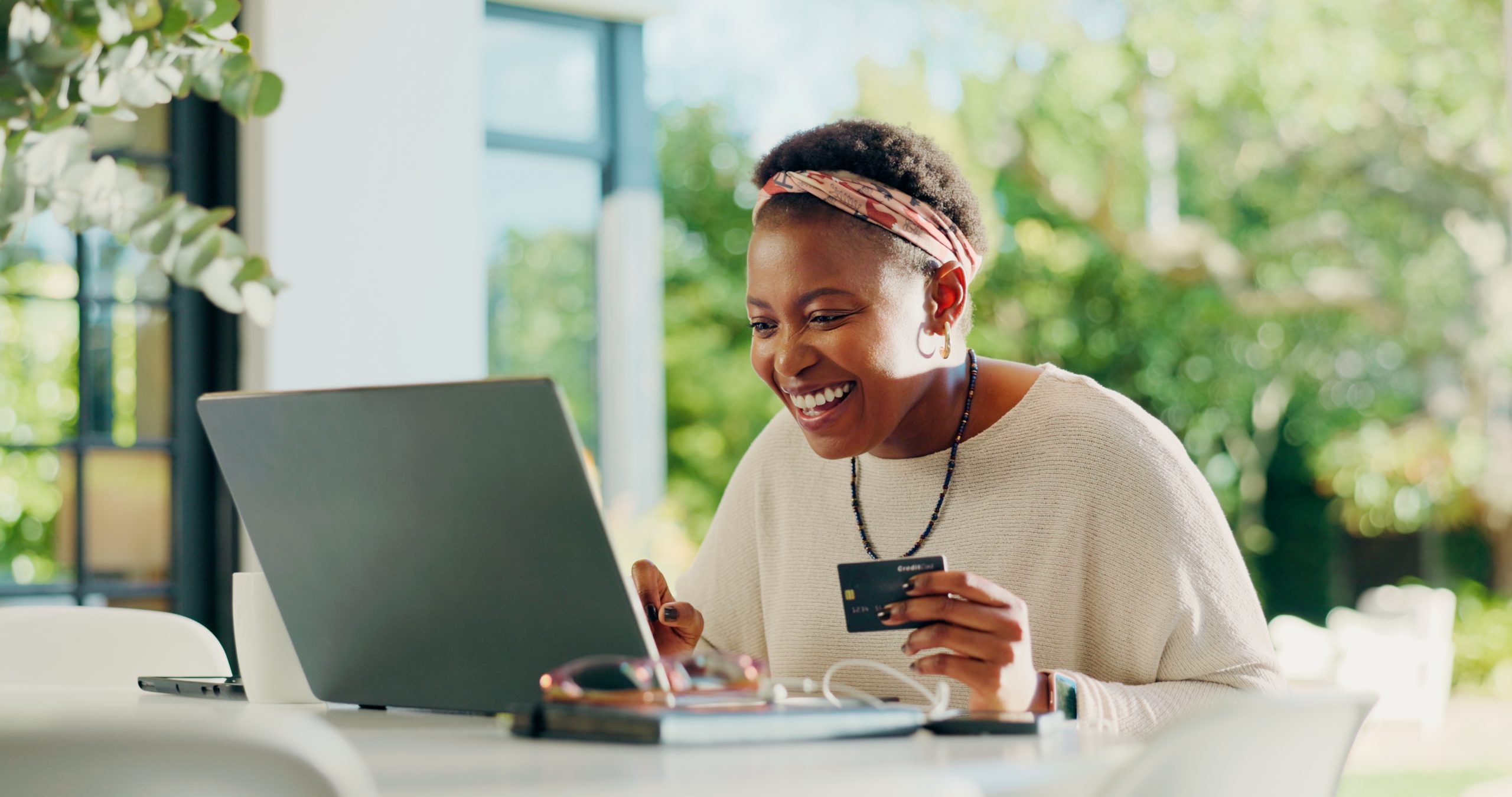 Black woman, laptop and credit card for payment in home with booking, typing and remote work on web. Person, virtual assistant and purchase for online shopping, ecommerce or easy transaction in house